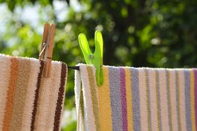 Laundry towels hanging on a clothesline secured with clothespins outdoors