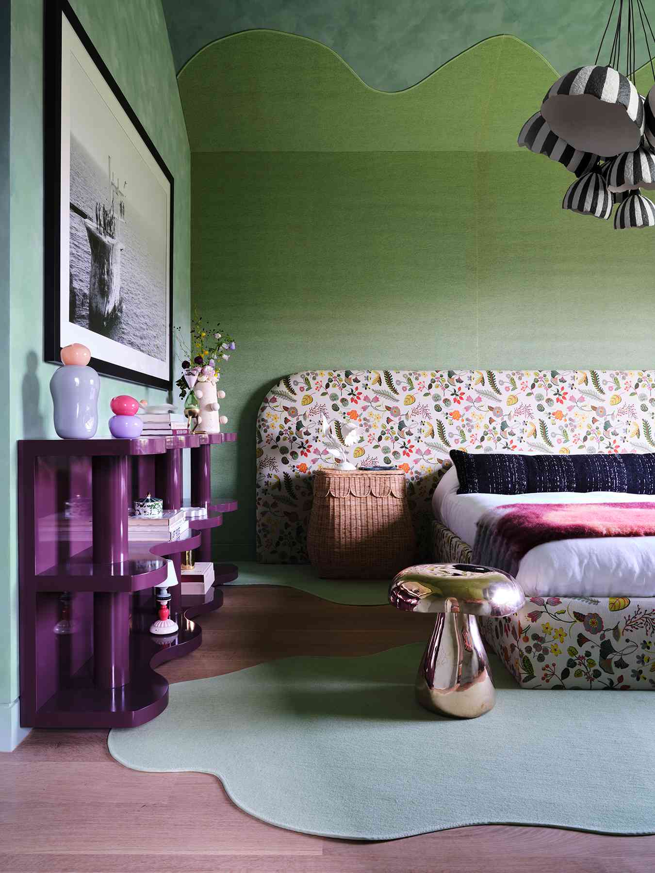 A bold, green and purple primary bedroom with an undulating rug that goes from the floor up the wall and onto the ceiling. 