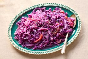 Braised red cabbage with apple and onion served on a platter with a spoon