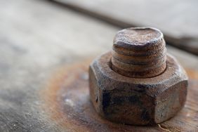 Closeup of a rusty bolt and nut on a wooden surface