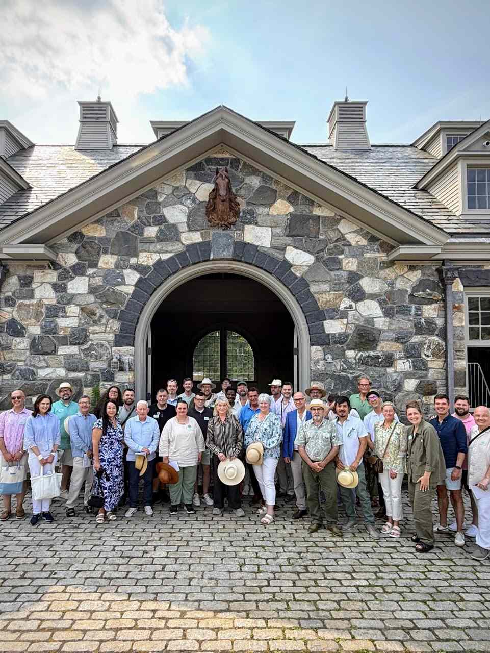 A group of people standing in front of a stone building with an arched entrance