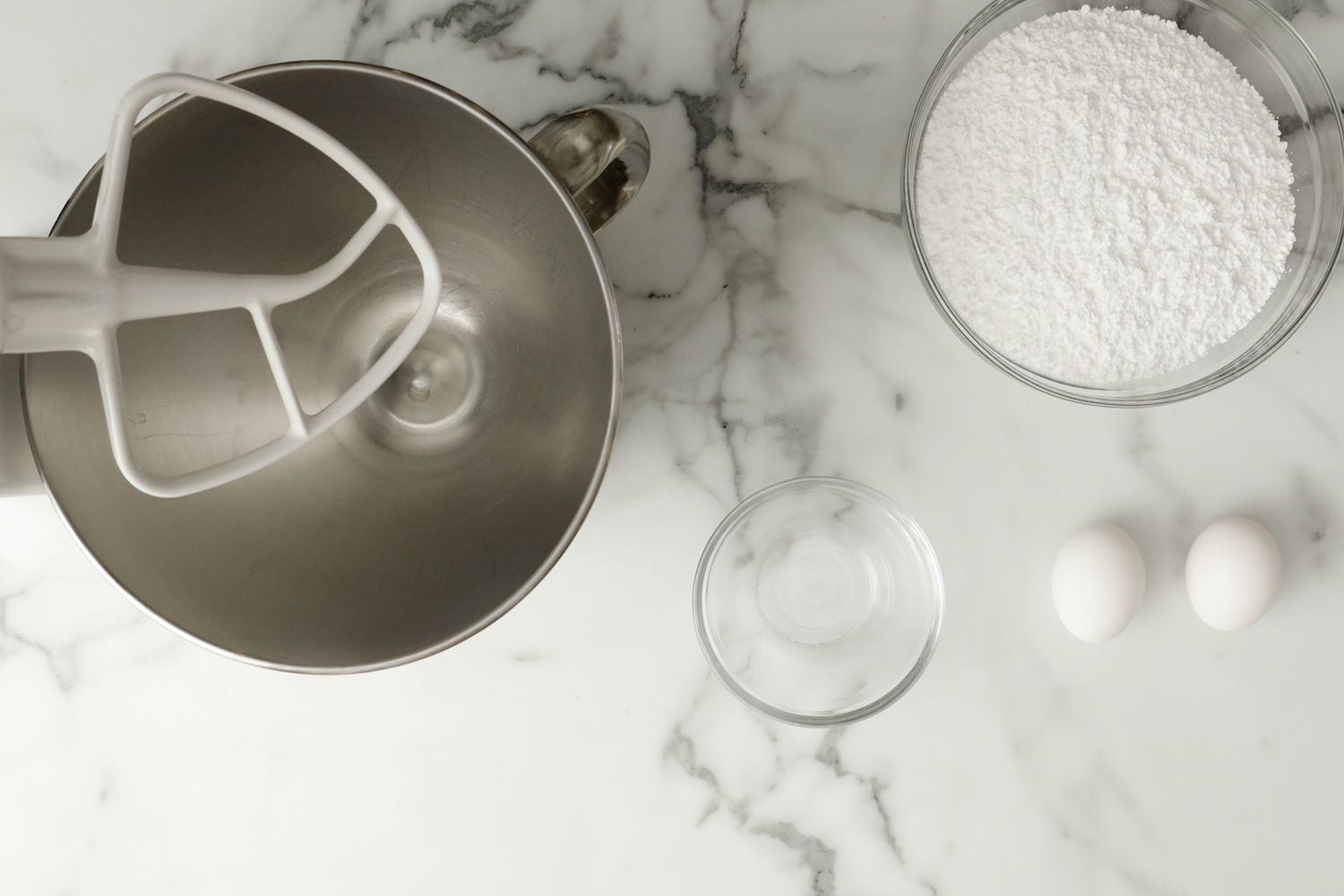 overhead view of mixing bowl, flour and eggs