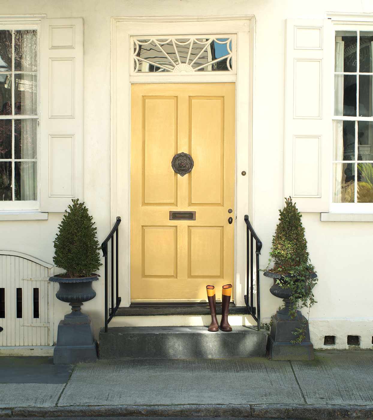 pale yellow front door on town house with tree decorations
