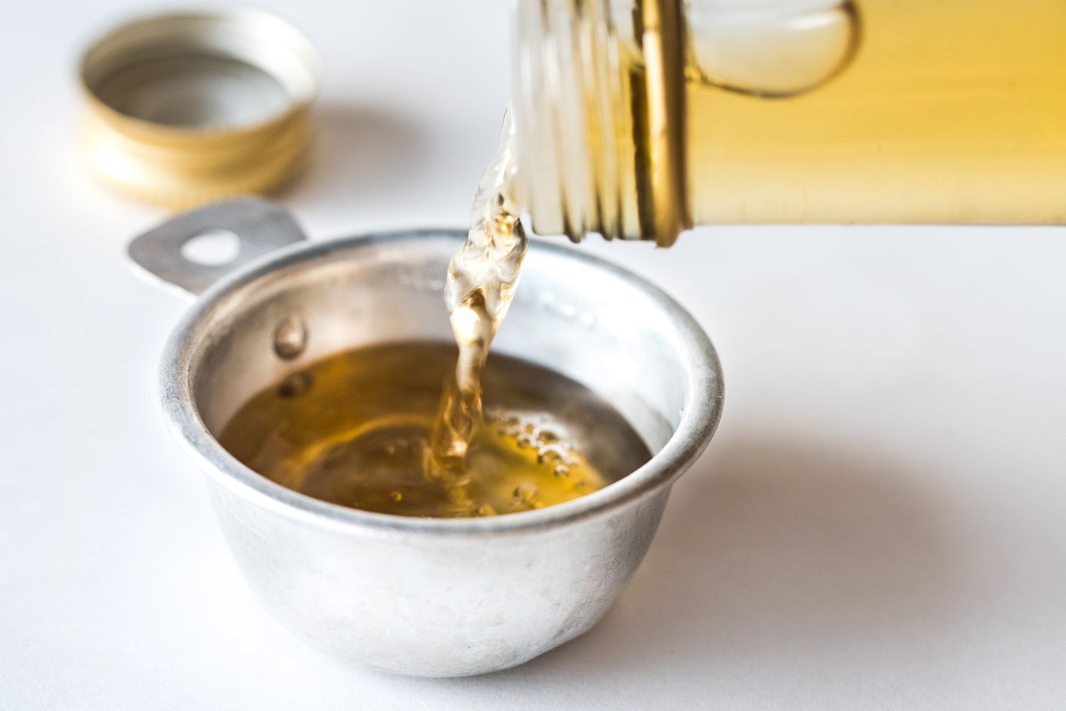 pouring white wine vinegar into measuring spoon