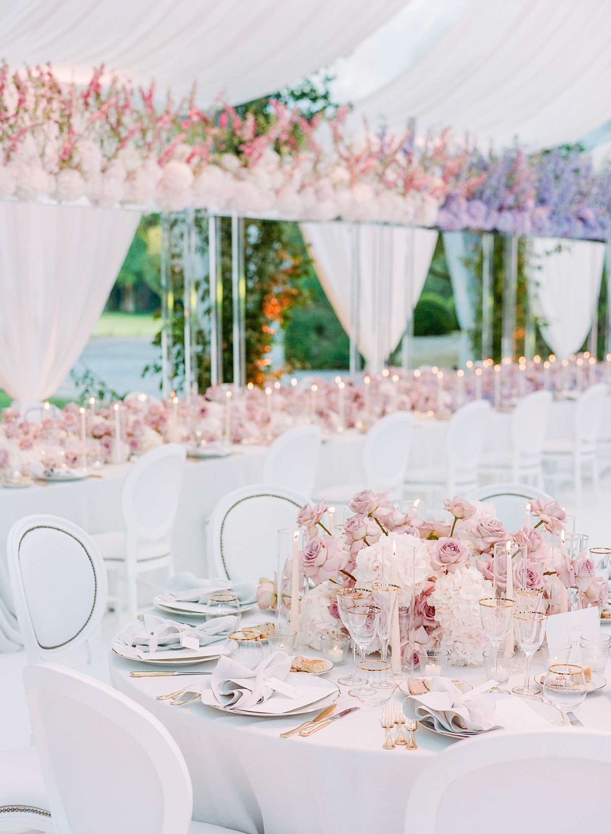 wedding reception table with pink floral centerpiece and gold utensils