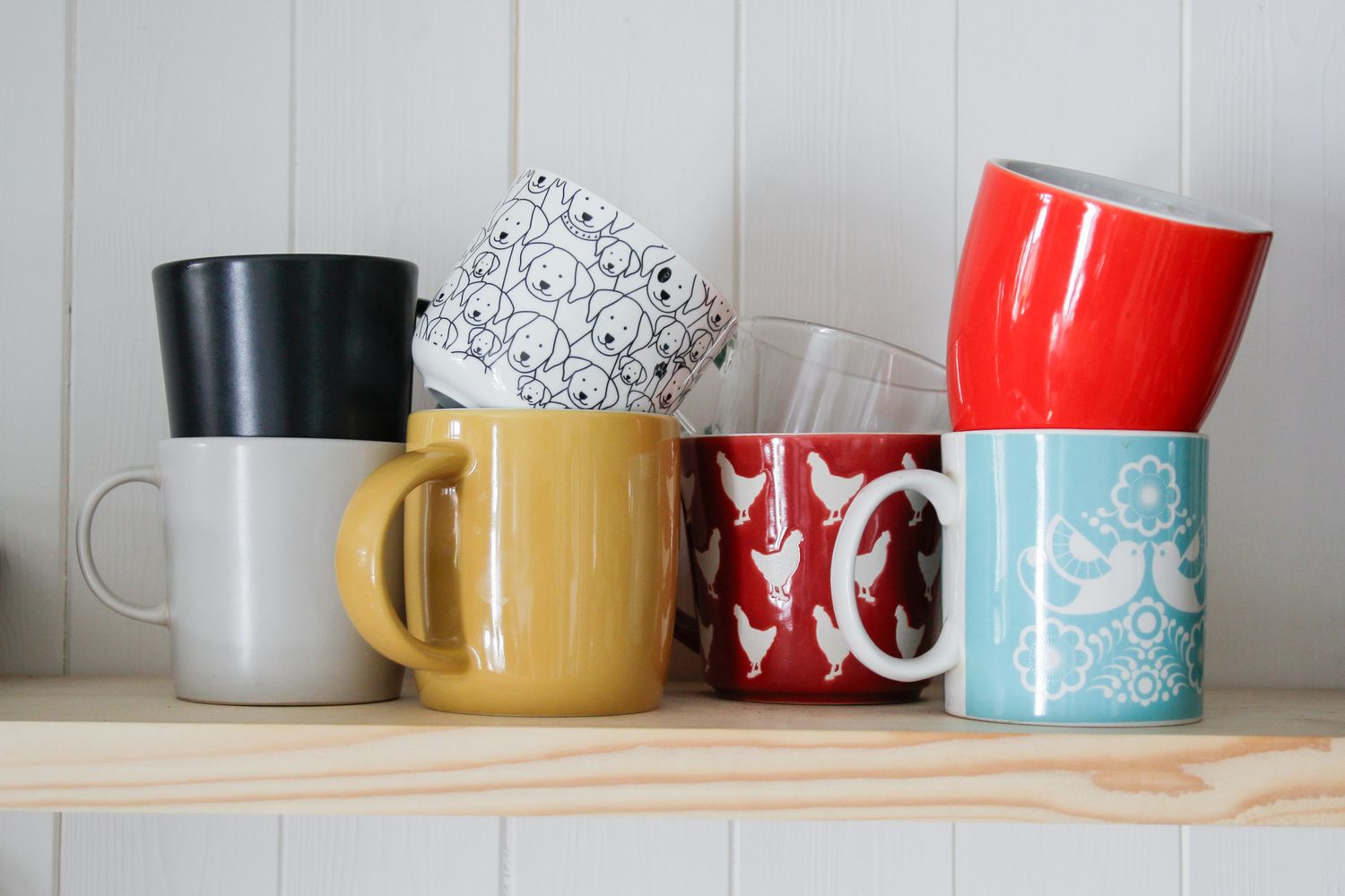A collection of assorted mugs arranged on a wooden shelf