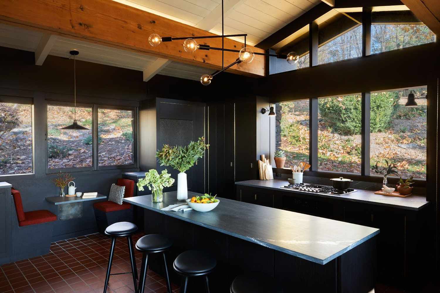 a black kitchen with wood ceiling