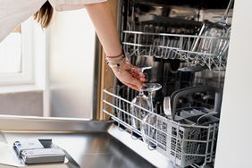 close up of woman unloading a clean dishwasher