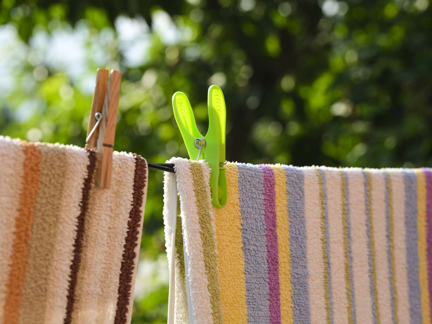 Laundry towels hanging on a clothesline secured with clothespins outdoors