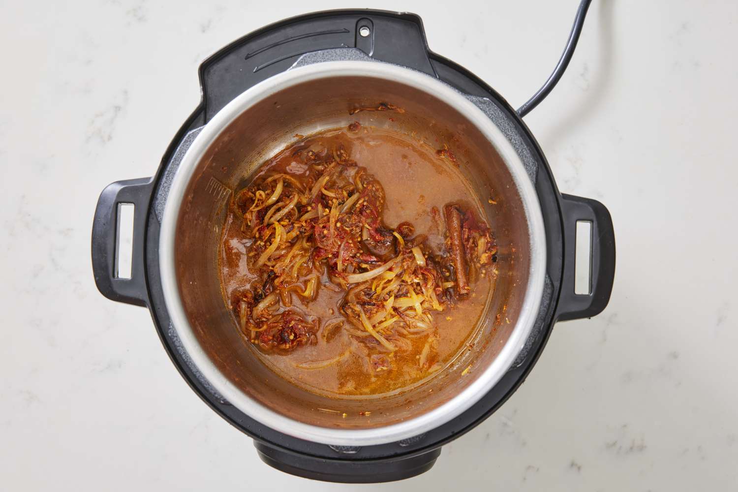 Broth, onions, spices cooking in instant pot