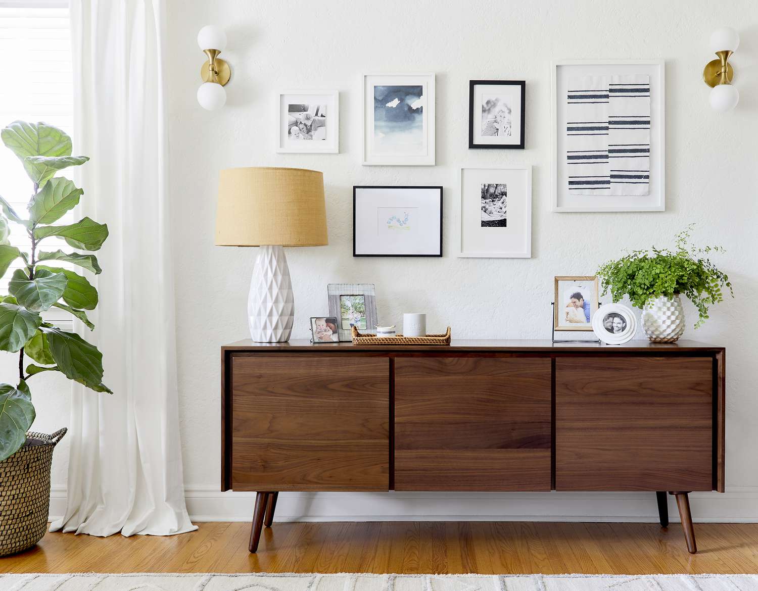 Modern room with credenza and plants, framed photos and prints