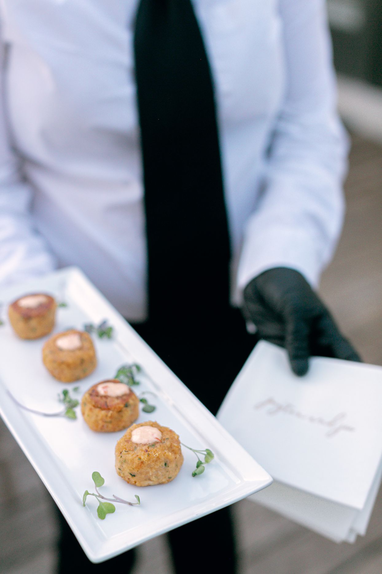 person holding white tray of wedding appetizers