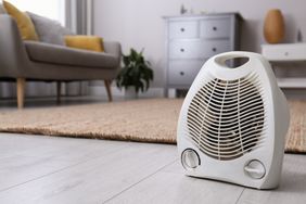 Space heater on the floor in a living room with furniture in the background