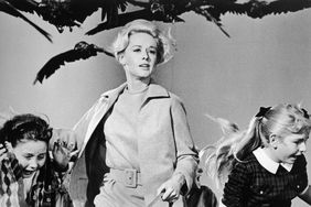Tippi Hedren in a scene with birds flying overhead