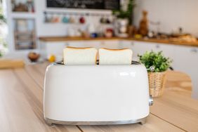 Toaster with two slices of bread on a kitchen counter