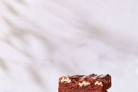fudgy turtle brownies stacked on cutting board
