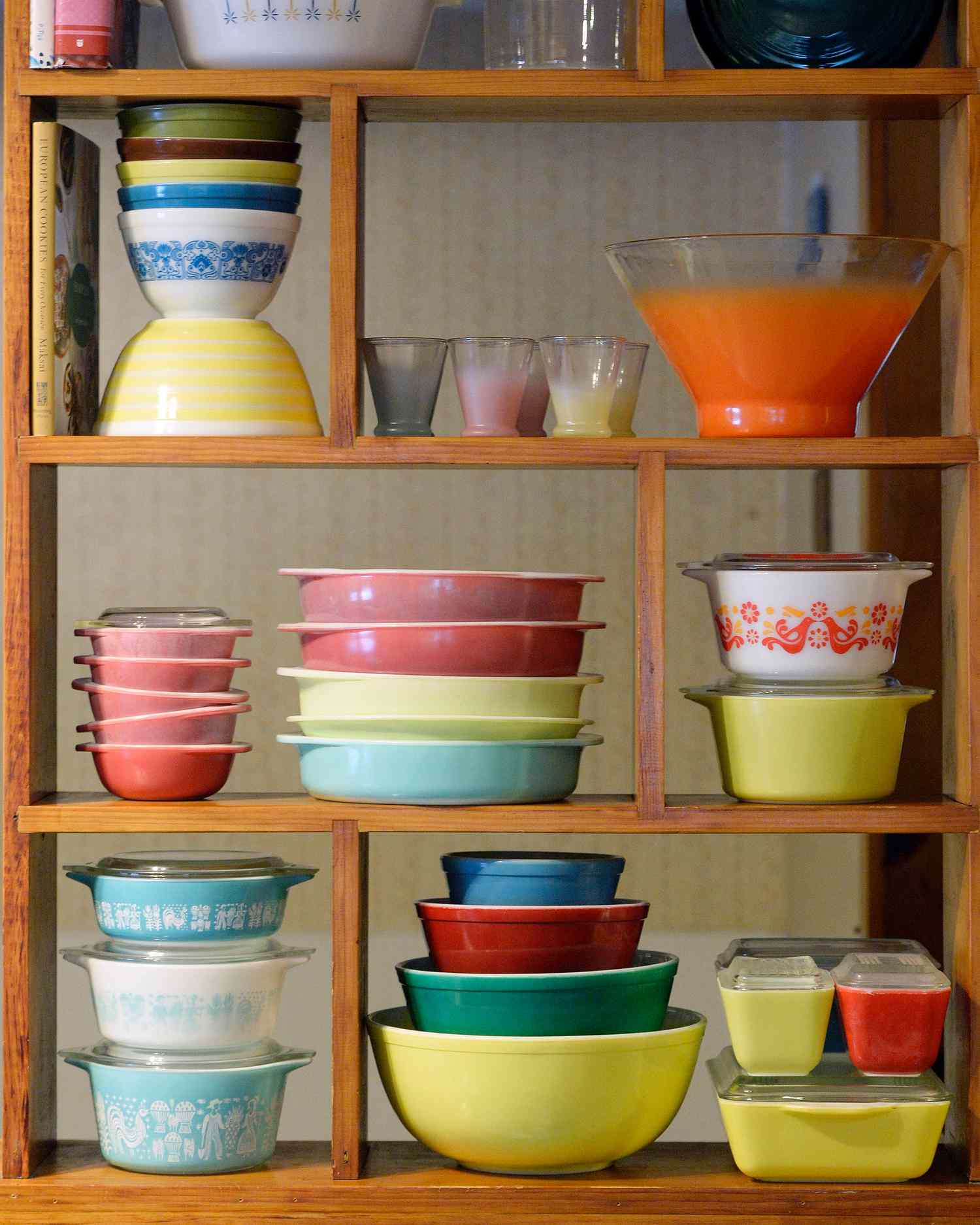 several vintage pyrex colorful dishes on a shelf