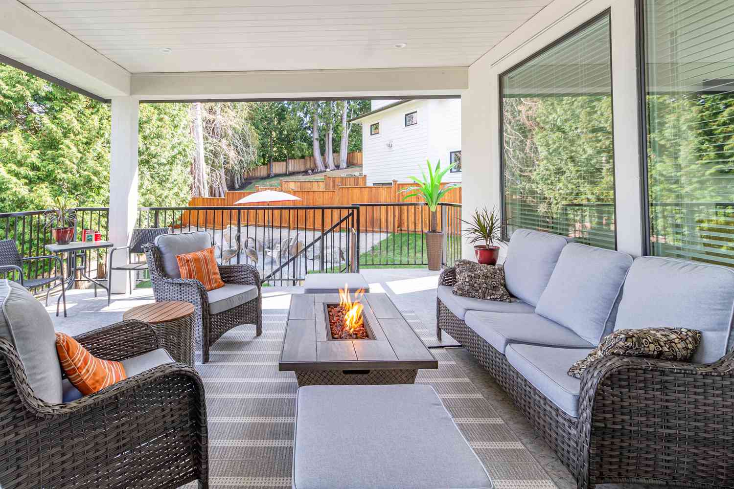 Outdoor sitting area with wicker chairs and a fire pit in a backyard patio setting