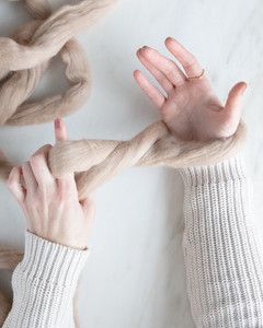 hands creating loop around wrist for arm knit blanket