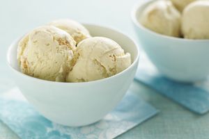 Two bowls filled with scoops of ice cream placed on bluepatterned napkins