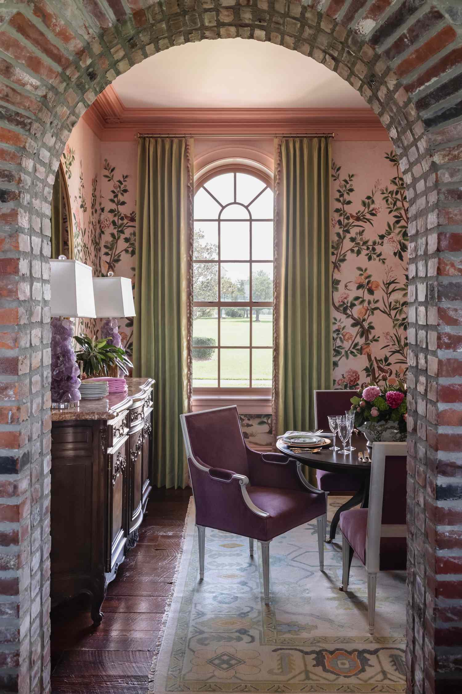 Dining room with oval table chairs and a decorative arched doorway