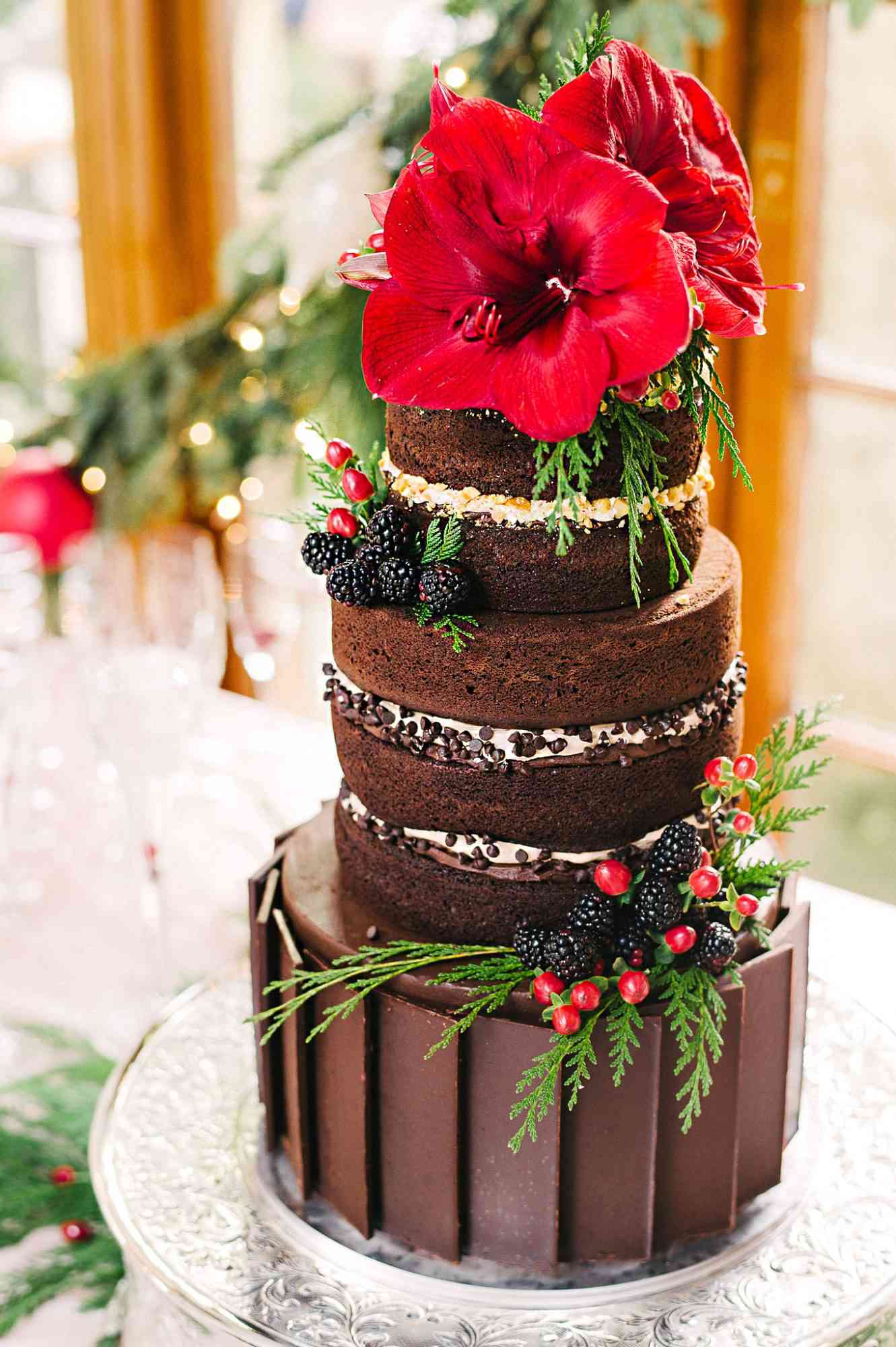 tall chocolate cake with blooms and berries