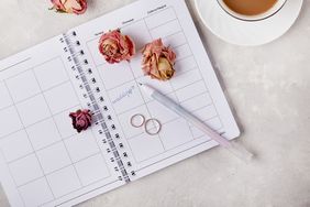 Open planner with flowers a pen and two rings arranged on it