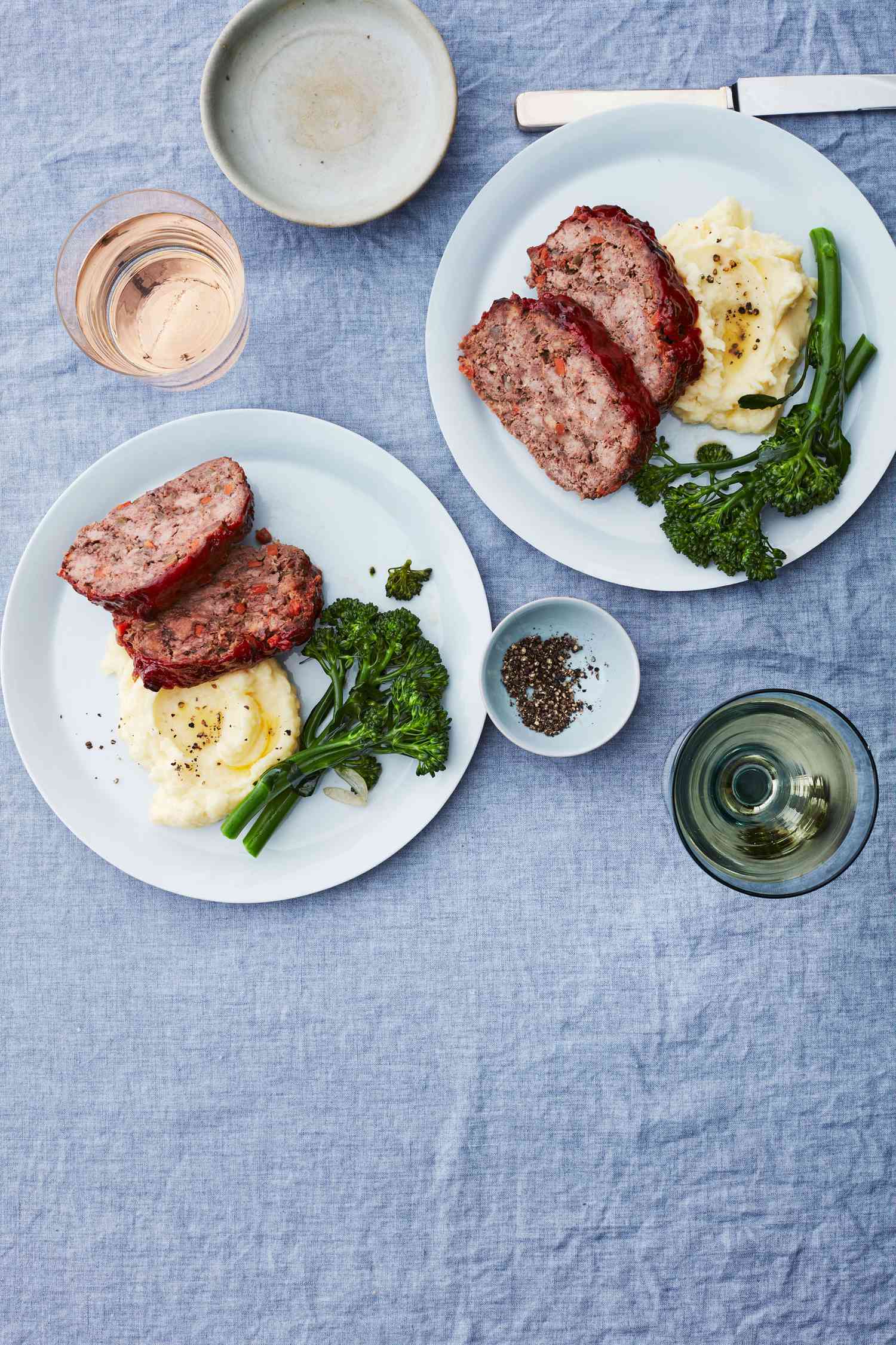 two plates of meatloaf potatoes and broccolini