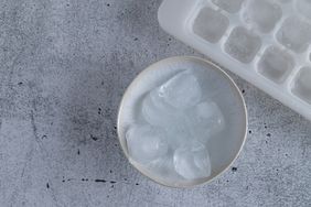 bowl of ice cubes next to an ice cube tray
