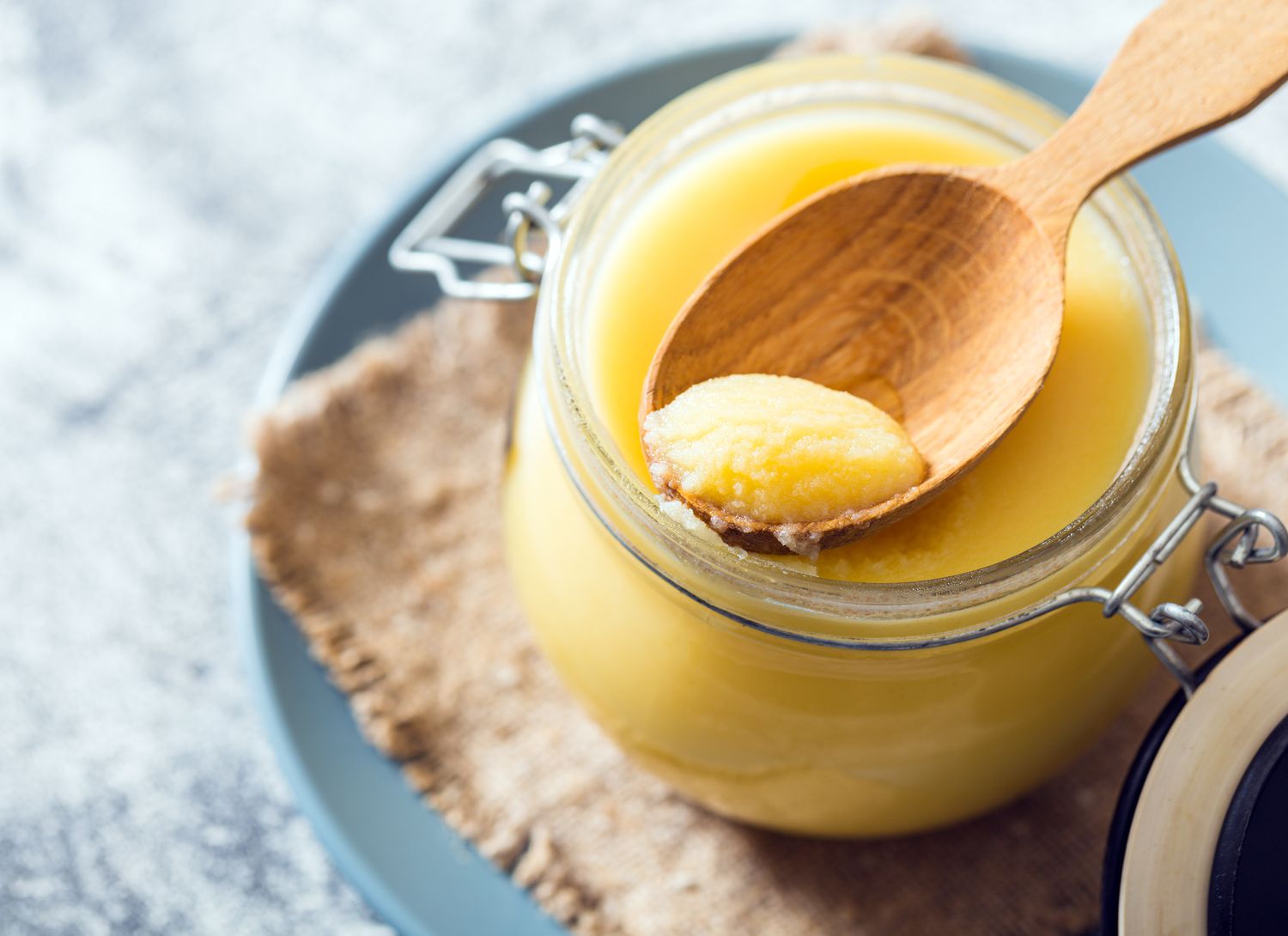 overhead view of a jar of ghee on blue plate