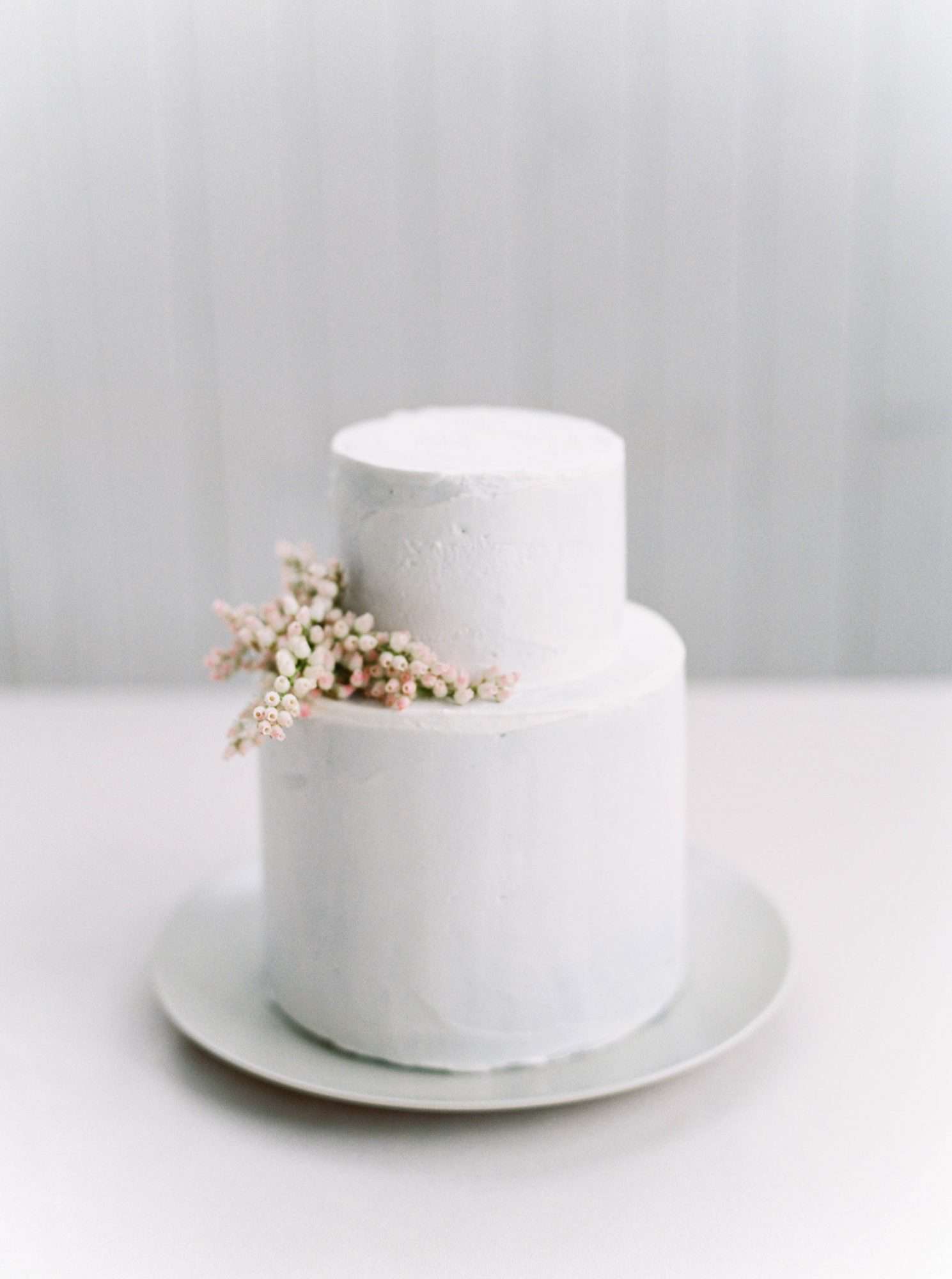 simple wedding cake adorned with sprig of andromeda