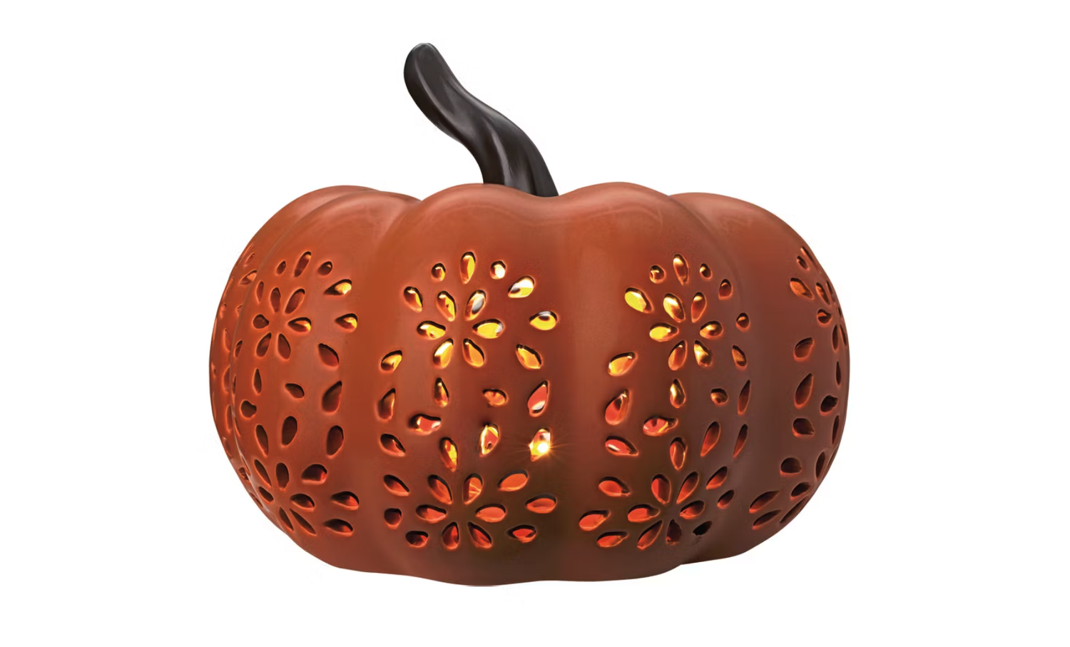 A ceramic pumpkin lantern with cutout floral patterns and illuminated interior