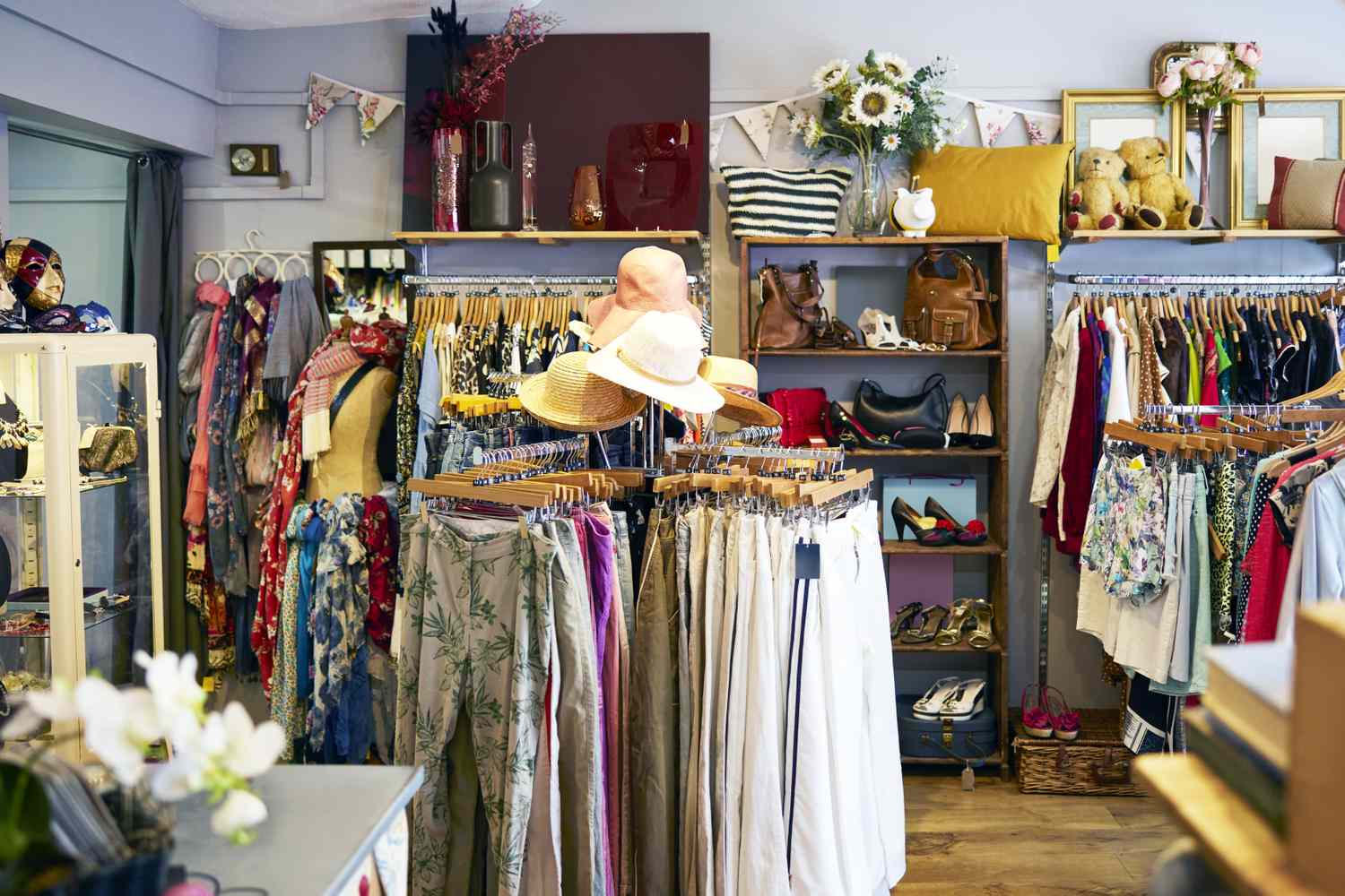 A clothing and accessories display in a boutique store racks of clothes shelves with bags and shoes