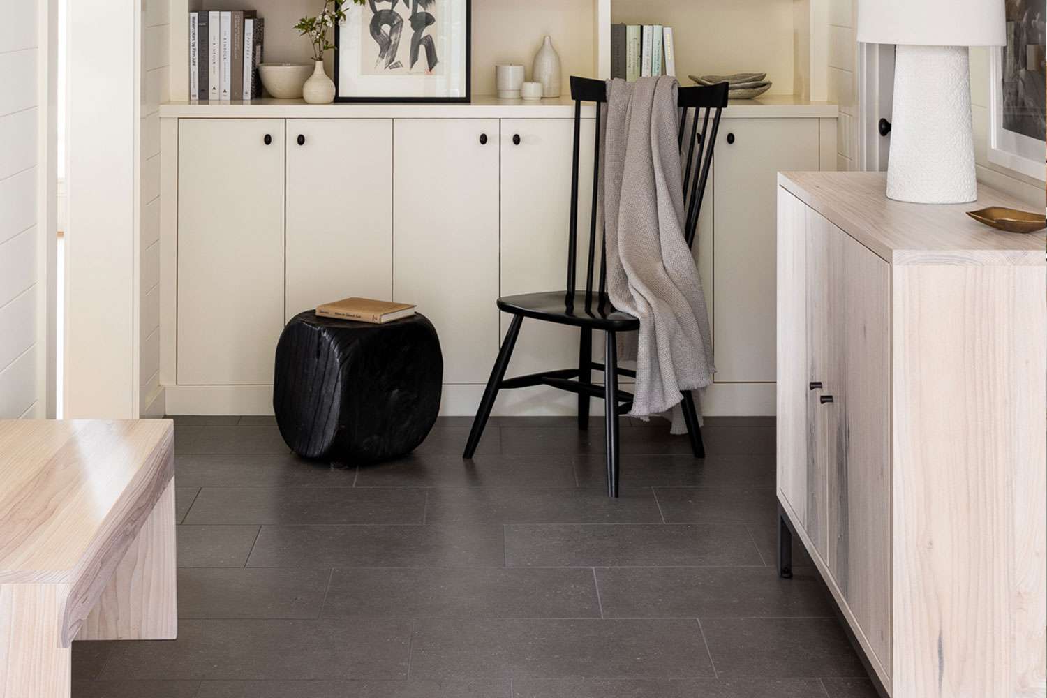 Hallway with dark tiled floor and neutral furniture