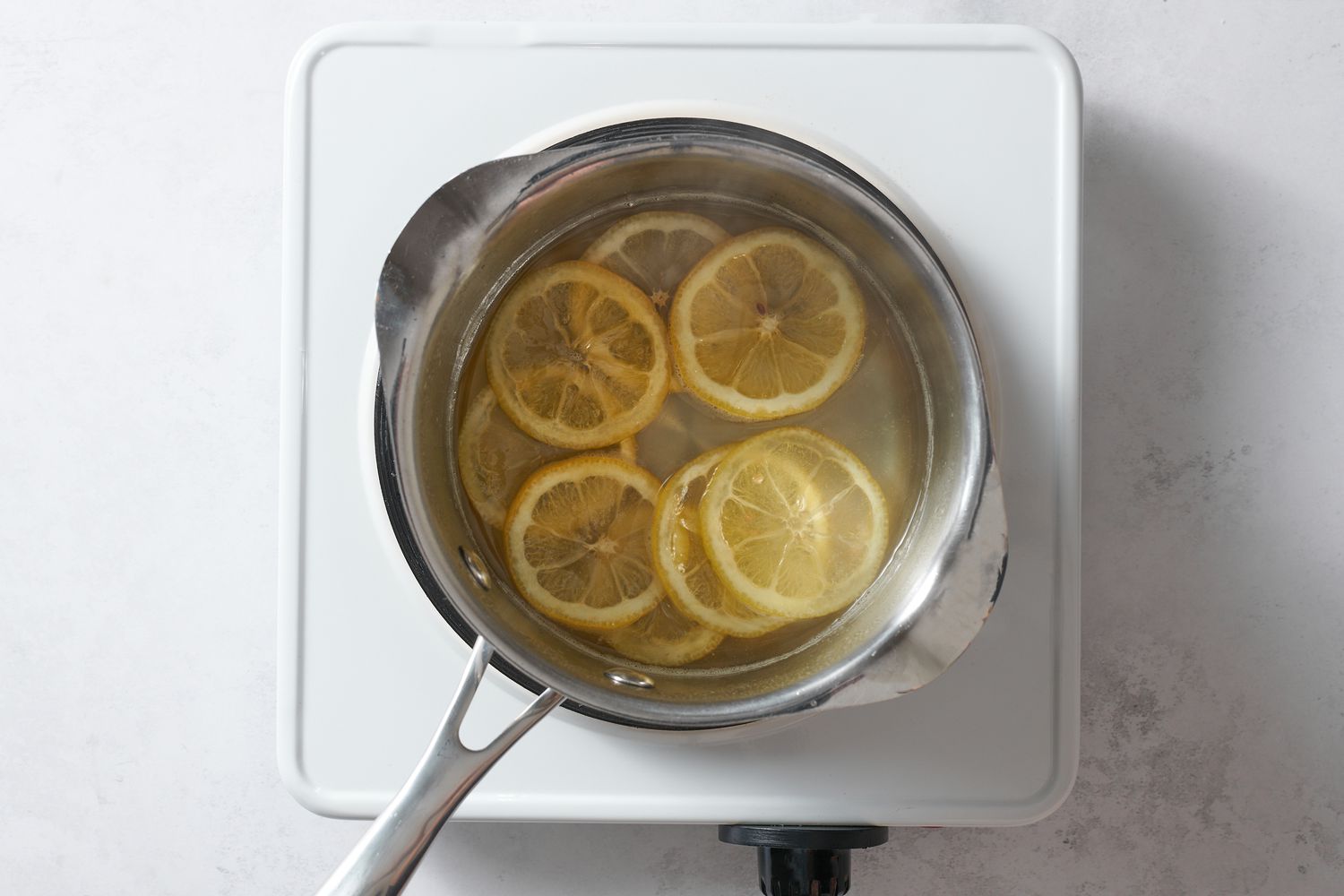 lemon slices in pan of sugar syrup