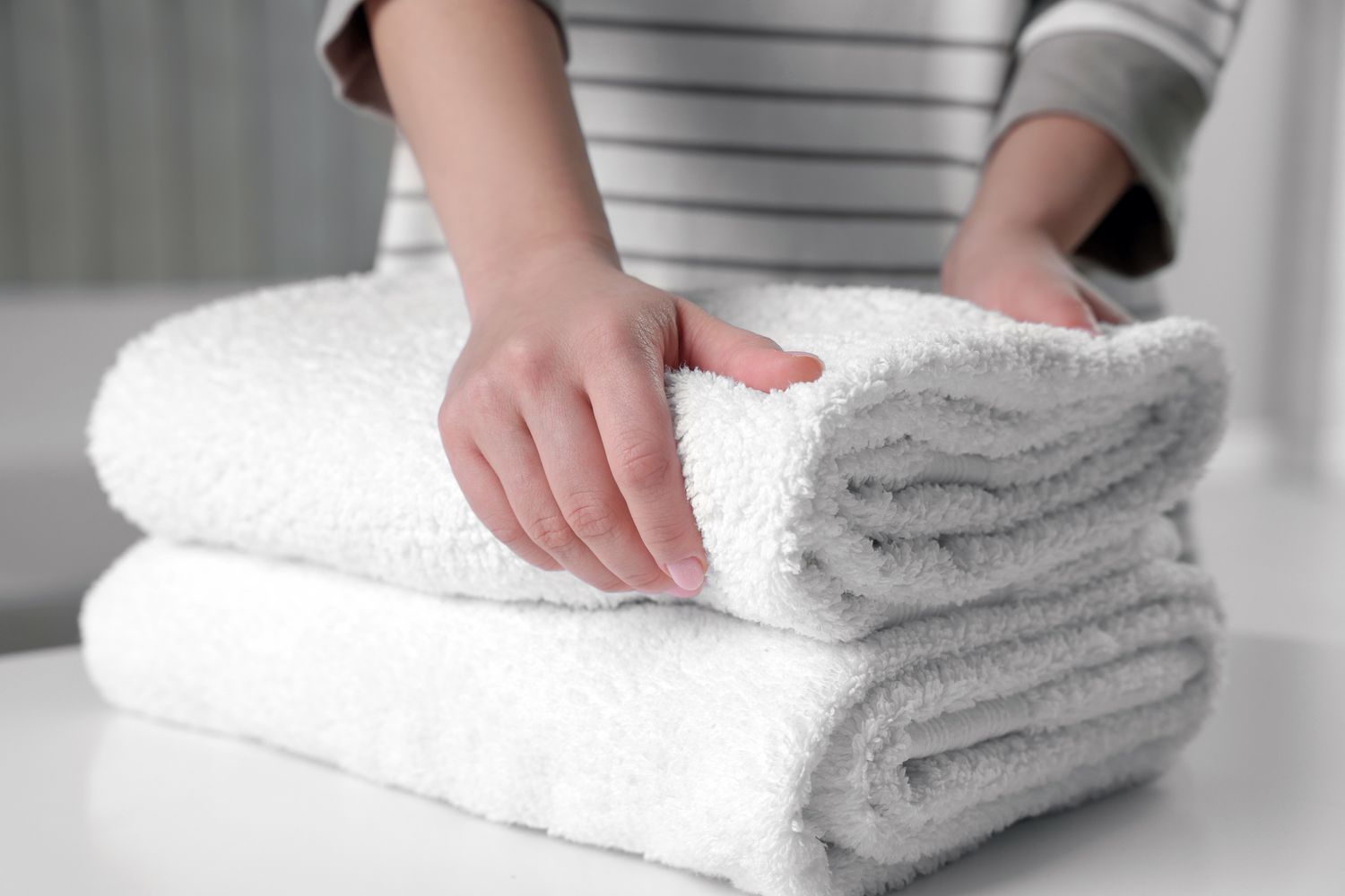 Hands folding freshly laundered towels