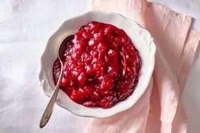 Bowl of cranberry sauce with a spoon on a napkin