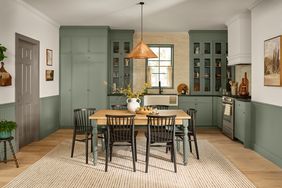 Kitchen interior with light green cabinets wood furniture and a woven rug