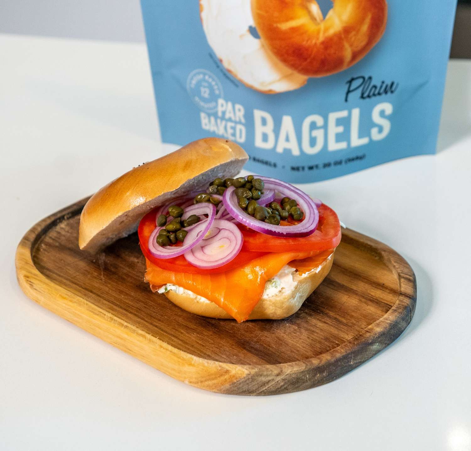 plain bagel sandwich with lox, cream cheese, tomato, red onion, and capers