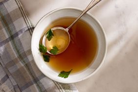 turkey bone broth in white bowl with spoon