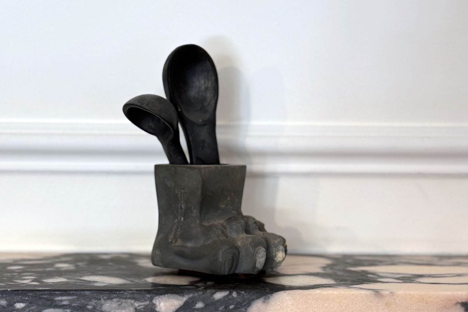 Sculpture resembling a foot with two utensil-shaped objects protruding