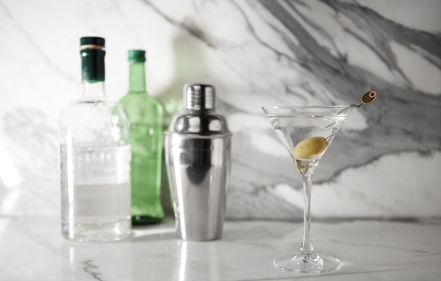 Gin cocktail with gin bottles in background
