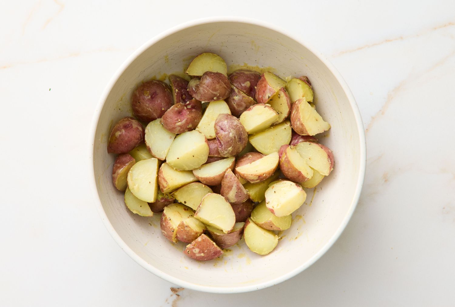 A bowl of sliced potatoes, likely prepared for a salad