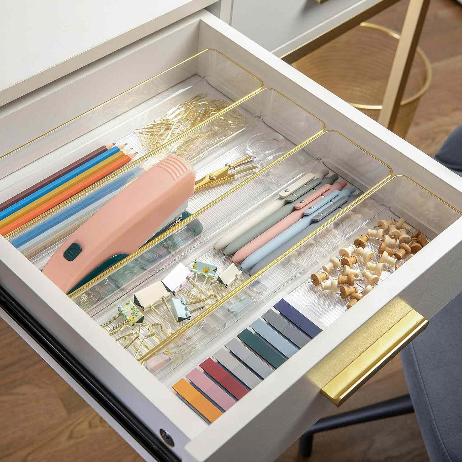 Open drawer containing neatly organized office supplies like pens paper clips and erasers