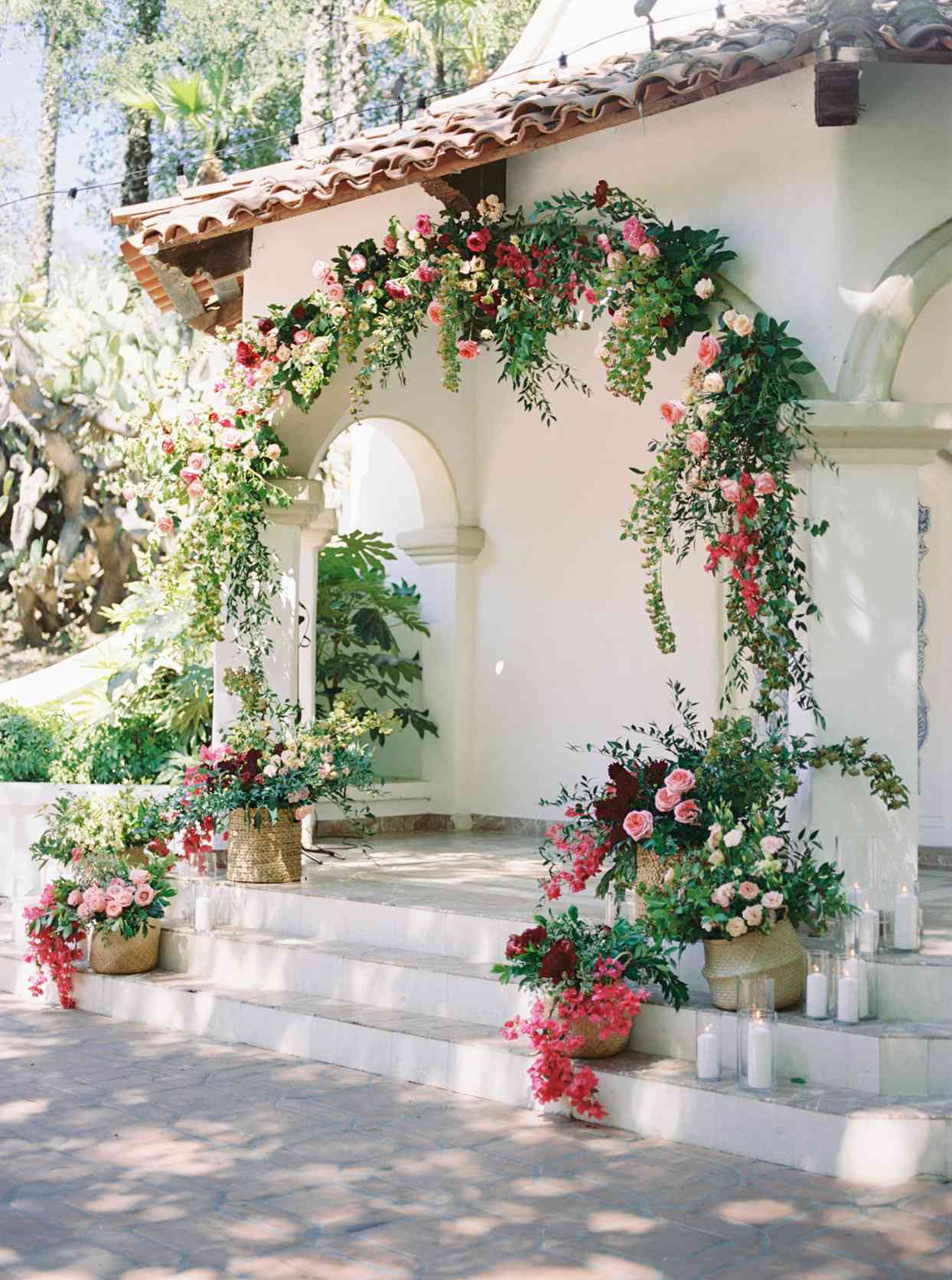 Wedding ceremony arch decorated with pink flowers and greenery