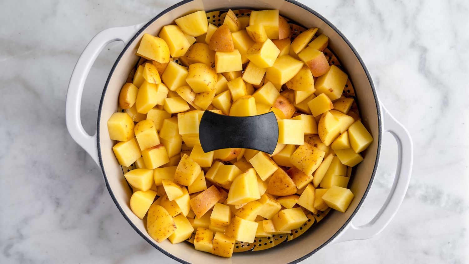 cubed raw potatoes in steamer basket