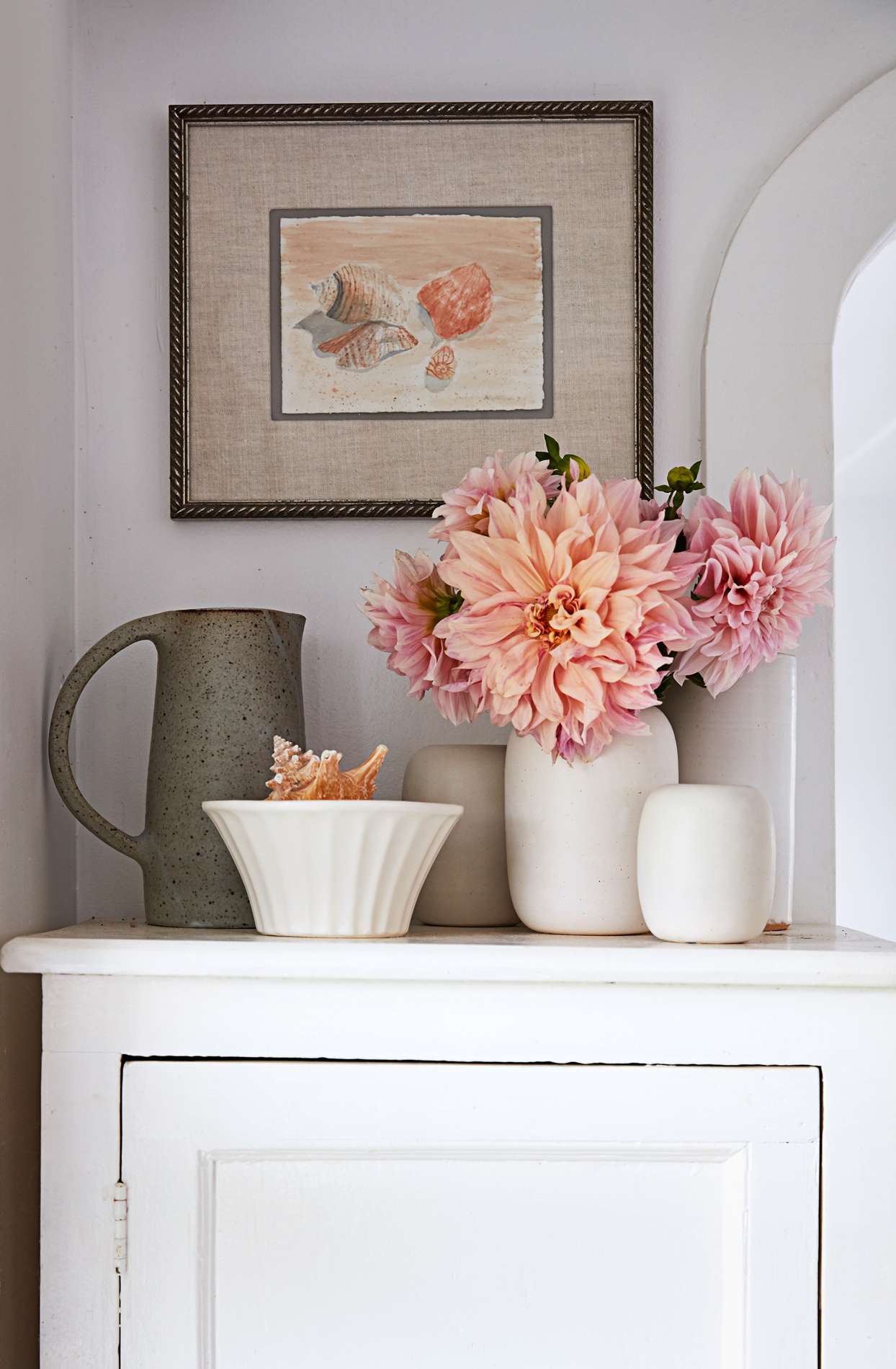 dahlias and ceramics displayed atop jelly cabinet
