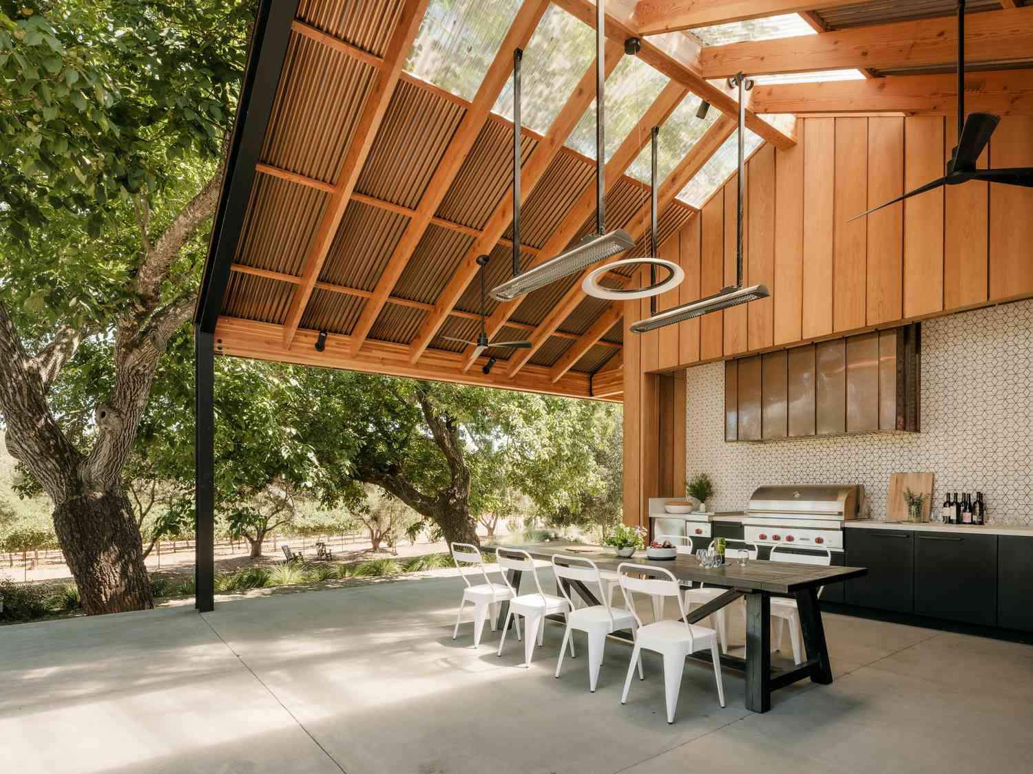 an open-air outdoor kitchen under a wooden barn roof