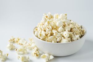A bowl filled with popcorn on a white surface