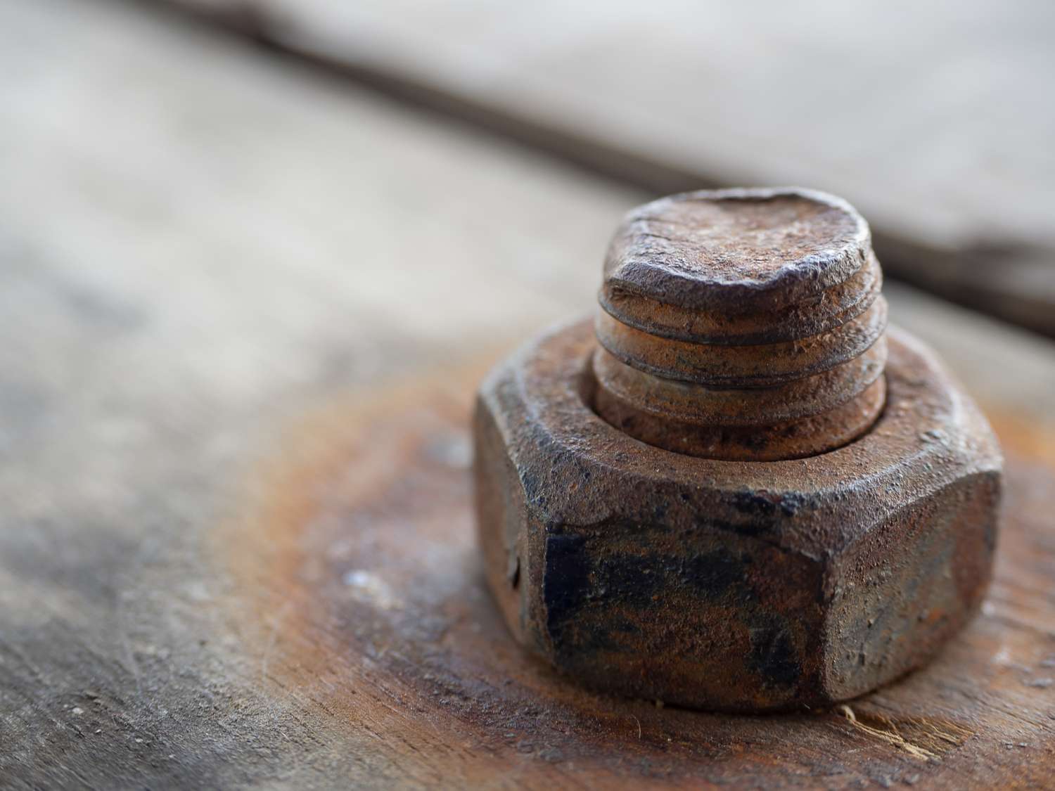 Closeup of a rusty bolt and nut on a wooden surface